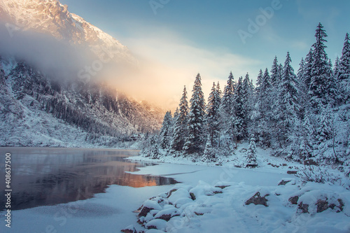 Winter mountain landscape in Canada. Wild snowy mountain near an icy lake. Forest in mountains nature at morning sunlight. © dzmitrock87