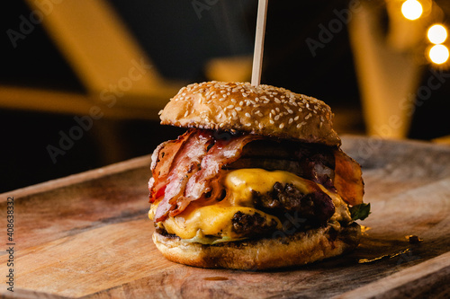 Photography Stacked burger filled with bacon, cheese, meat, sauce, relish and mushrooms