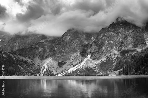 Majestic black and white storm cloud over mountain lake
