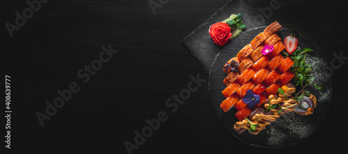 set of sushi roll with salmon, avocado, cream cheese, cucumber, rice, caviar, eel in plate on black wooden table background