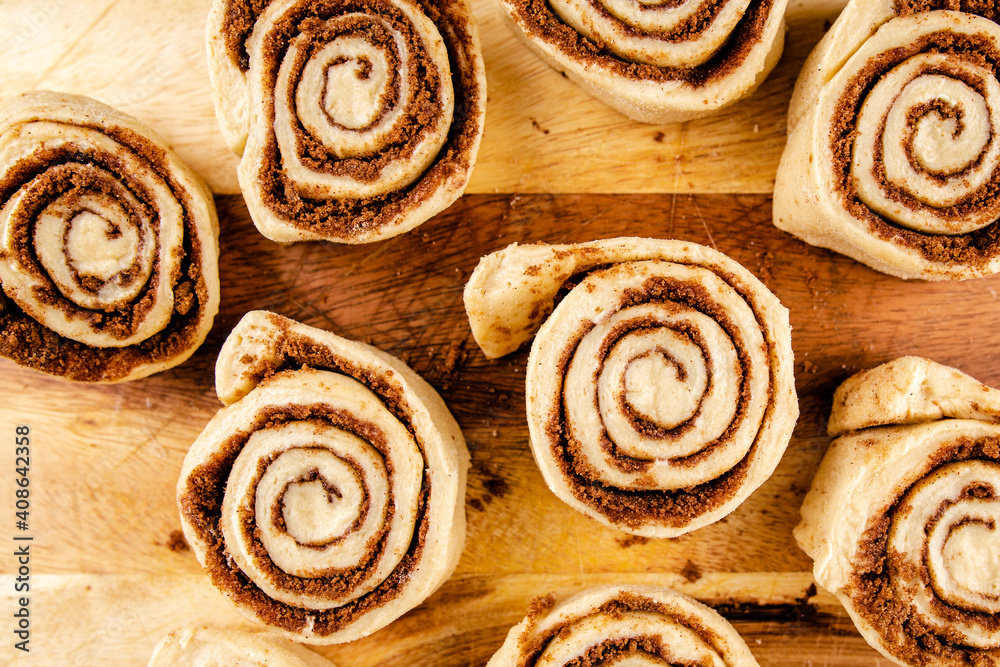 Raw cinnamon roll dough being prepared ready for baking