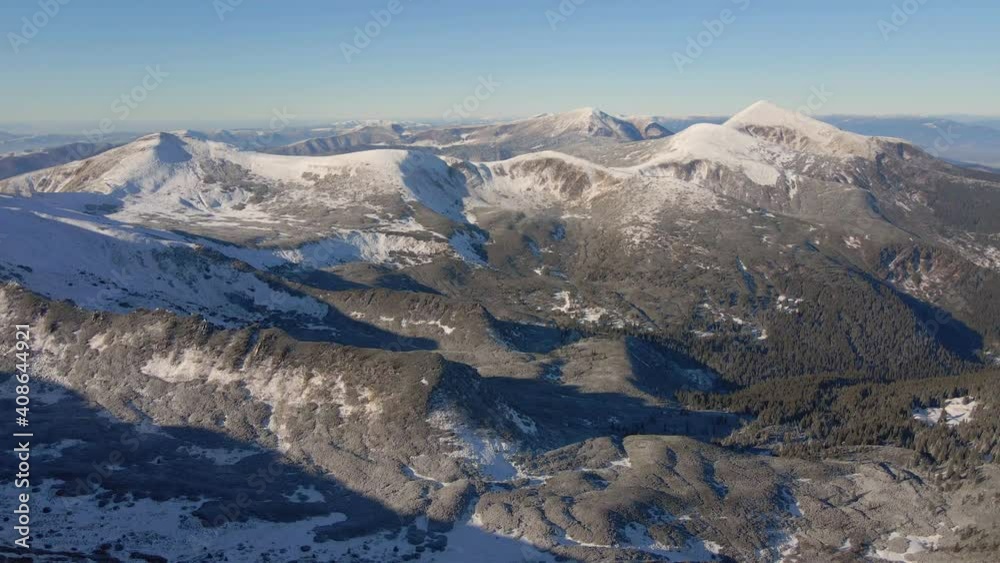 Aerial view of winter mountains. Mount Hoverla, Petros. Snow-capped peaks of the Carpathians on a sunny day. Aerial view of winter mountains. Mount Hoverla, Petros. Snow-capped peaks of the Carpathians on a sunny day.
