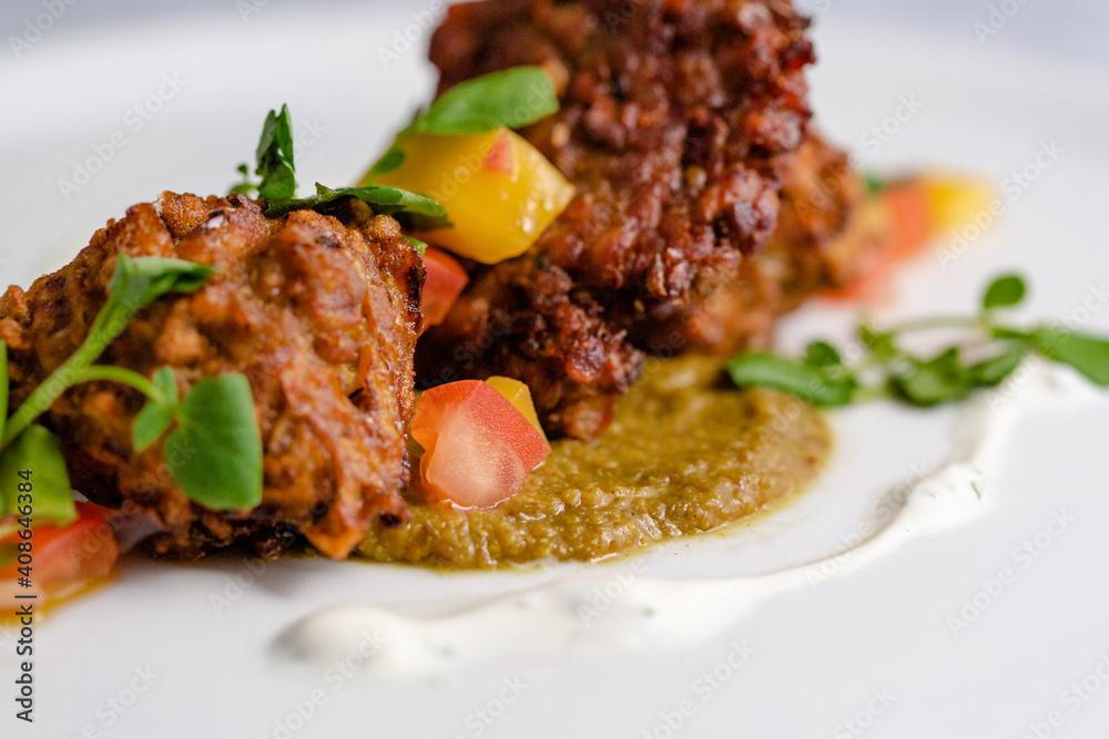 Onion bhaji with chili sauce on a white plate Onion bhaji with chili sauce on a white plate