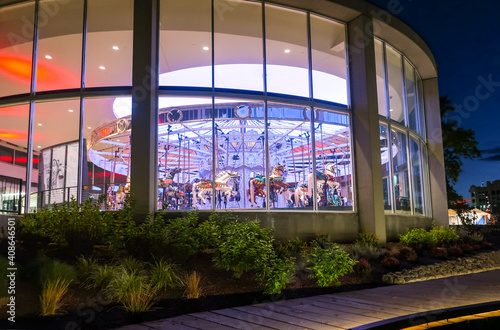 A colorfully illuminated carousel seen at night from the outside in Spokane, Washington, USA