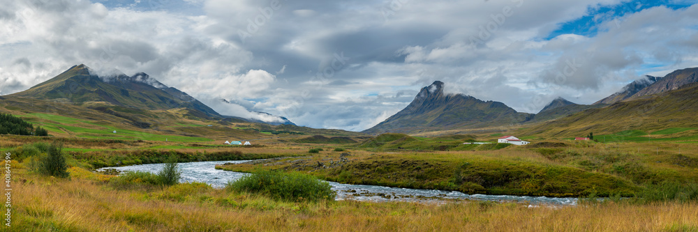 Panoramic shot of farms and mountains against cloudy sky, Northern Iceland, Iceland, Europe Panoramic shot of farms and mountains against cloudy sky, Northern Iceland, Iceland, Europe