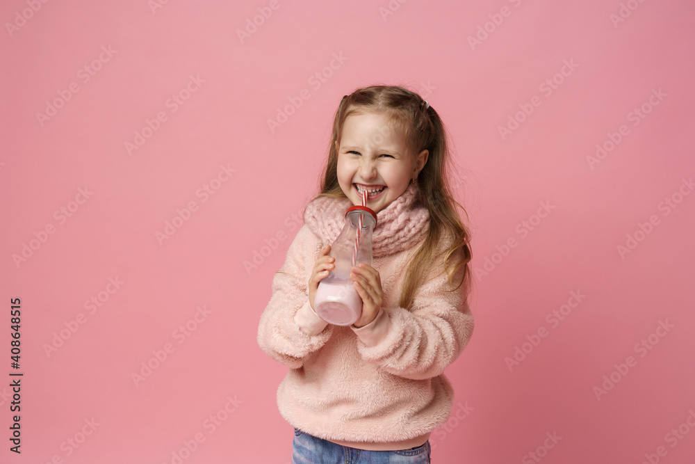 little girl in a fluffy sweater and a headband, smiling with a doughnut in her hand. Sweet appetizer, delicious pastries. a child shows a delicious dessert on a pink background in studio little girl in a fluffy sweater and a headband, smiling with a doughnut in her hand. Sweet appetizer, delicious pastries. a child shows a delicious dessert on a pink background in studio