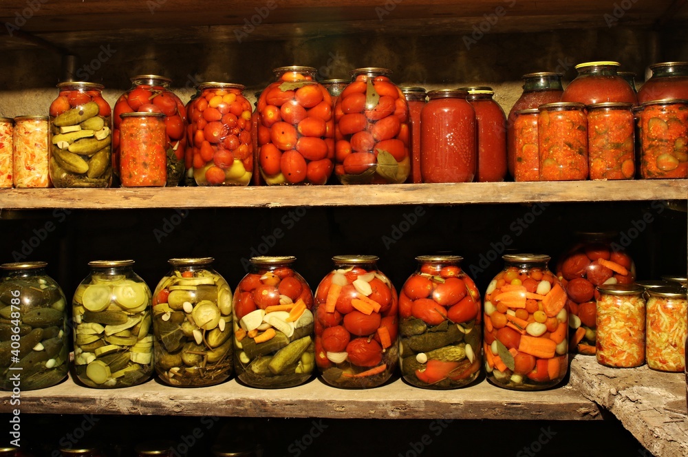 Home made vegetables canned in glass jars are displayed on shelves in the basement