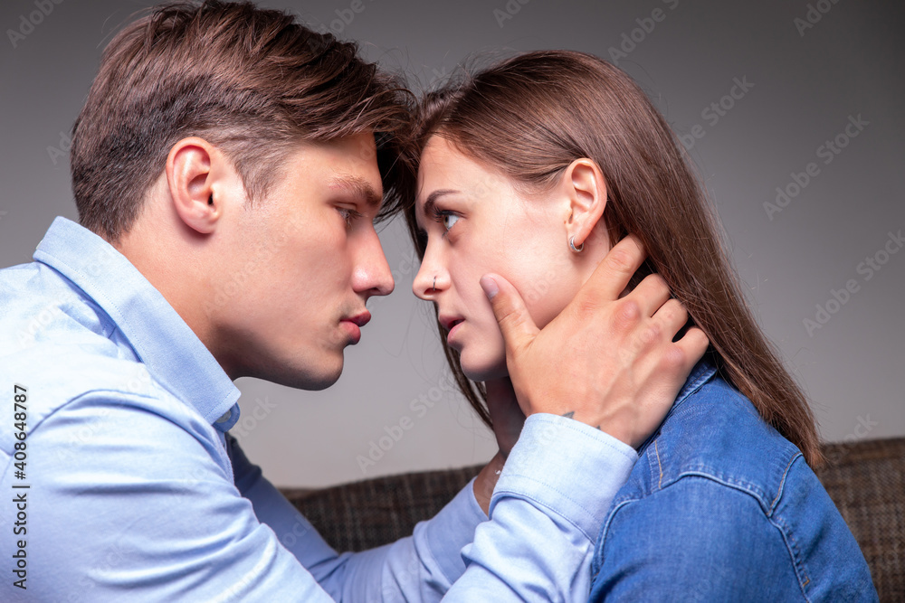 Affectionate handsome man hugging young girl on neck, begging her pardon, couple in love enjoying moment of closeness