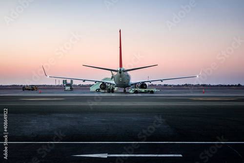 airplane standing on the airport runway at sunset