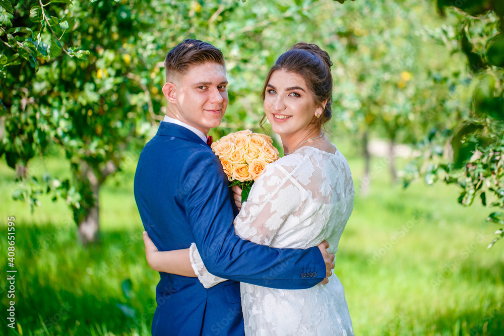 The bride and groom are walking their backs in the forest and admire nature and look at the landscape. Wedding ceremony and photo shoot outdoors. Newlyweds. Rear view. The bride and groom are walking their backs in the forest and admire nature and look at the landscape. Wedding ceremony and photo shoot outdoors. Newlyweds. Rear view.