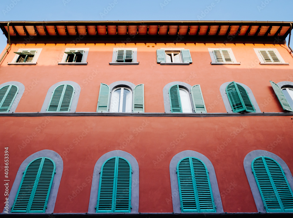 Exquisitely decorated Italian facade walls with pivoting windows in an old historic building.