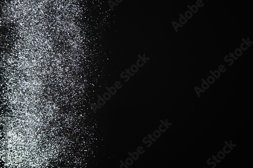 Luxury background concept made of silver shiny glitters dust gradient on dark surface, modern and elegant concept, flat lay, top view