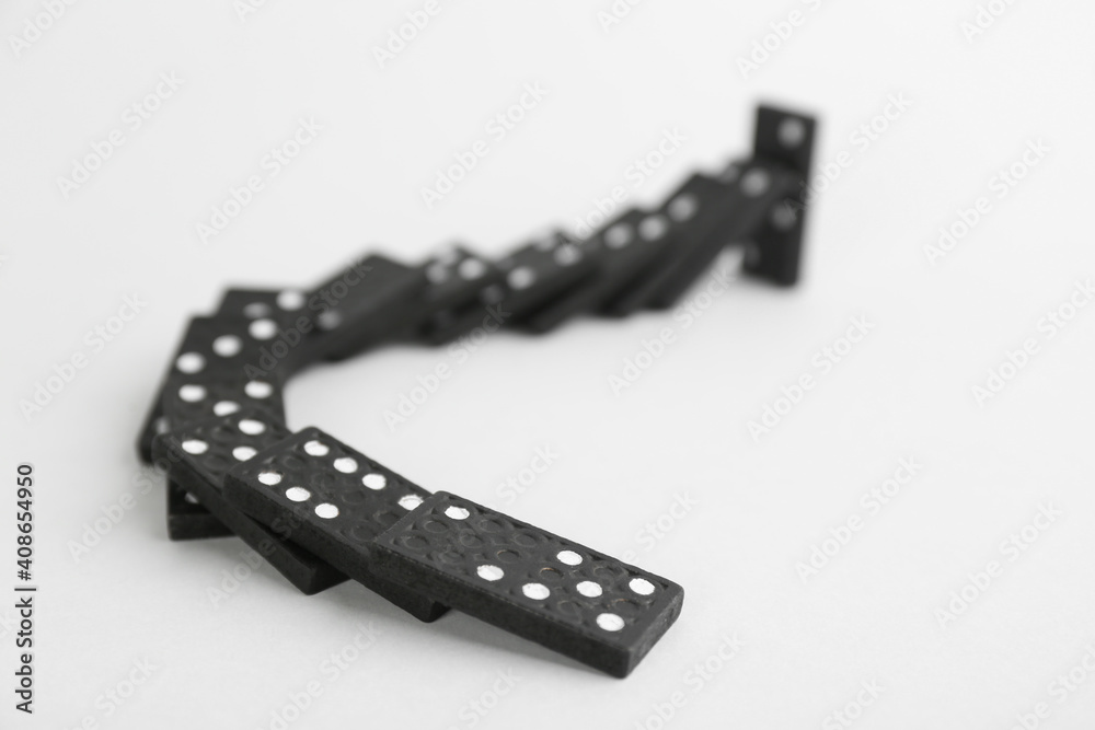 Black domino tiles falling on white background Black domino tiles falling on white background