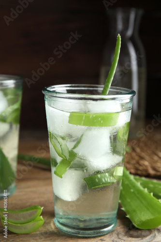 Fresh aloe drink with ice cubes on wooden table