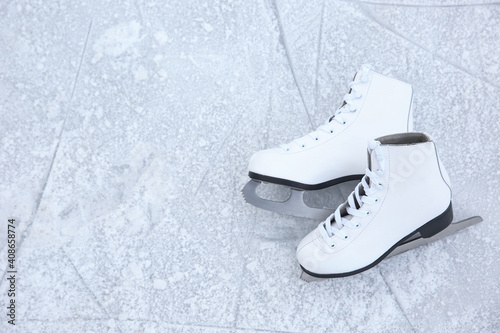 Pair of figure skates on ice, top view with space for text. Winter outdoors activities