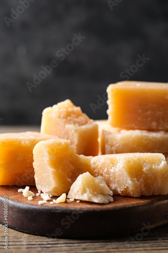 Parmesan cheese with wooden board on table, closeup