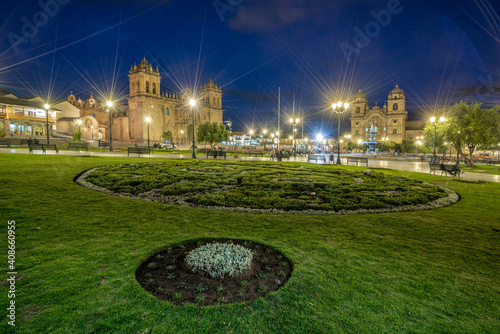 Illuminated park by Cusco Cathedral and Church of the Society of Jesus at Plaza de Armas at night, Cusco, Peru photo