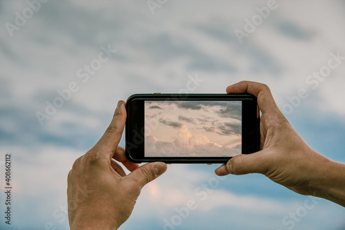 Phone taking picture of clouds at sunset. photo