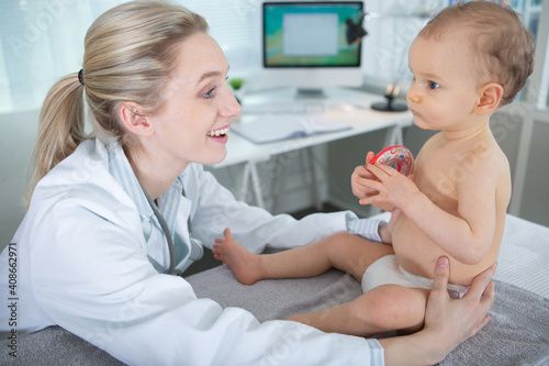 happy doctor examining little baby