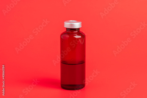 Macro Image Of Amber Vaccine Vial Set On Red Background