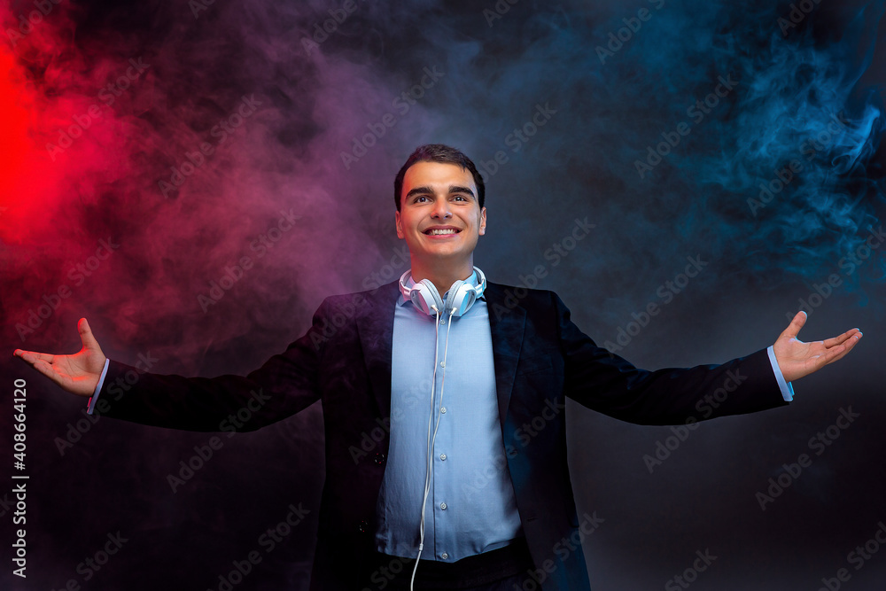 Portrait of man with headphones on dark background with smoke. Looking up. Studio shoot.