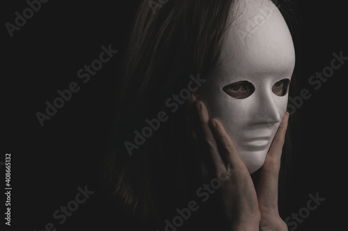 portrait of a woman in a white mask in the dark photo