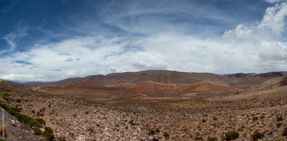 Desert landscape. Panorama view of the arid land, valley and mountains under a dramatic sky with clouds. 