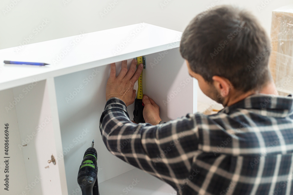 Carpenter measuring shelves that are parts of new kitchen with meter. Carpenter measuring shelves that are parts of new kitchen with meter.