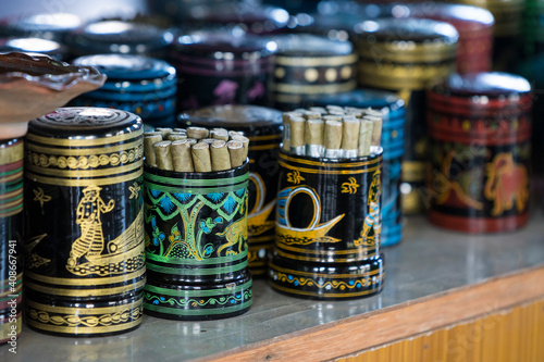 Burmese cigars in colorful painted containers on display in cheroot workshop, Lake Inle, Myanmar photo