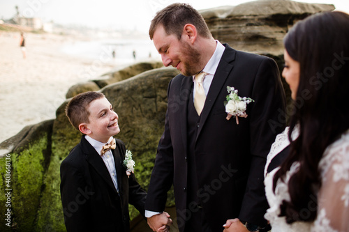 Newlyweds Posing with Nine Year Old Son on Beach in San Diego photo