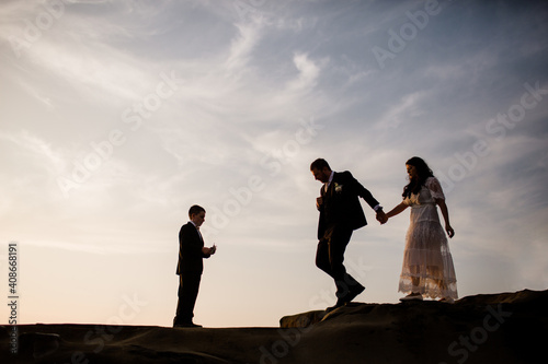 Newlyweds & Nine Year Old Son Standing on Rock at Beach in San Diego photo