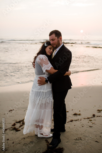 Newlyweds Posing on Beach at Sunset in San Diego photo