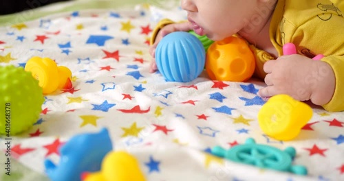 infant, childhood concept - close-up of smiling happy Baby plays with a teether. Teeth cutting. First teeth. Joy toothless 7 months baby bite, gnaws teether toy