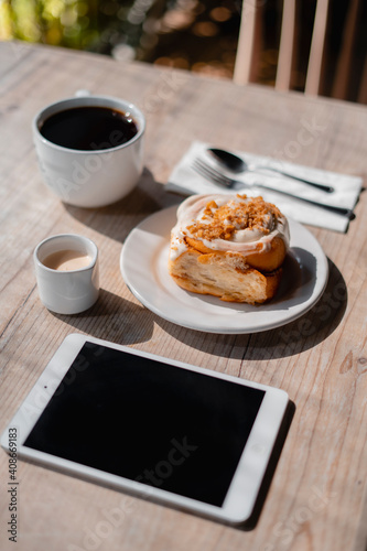 desayuno café con pan rol de canela e ipad en mesa de madera 