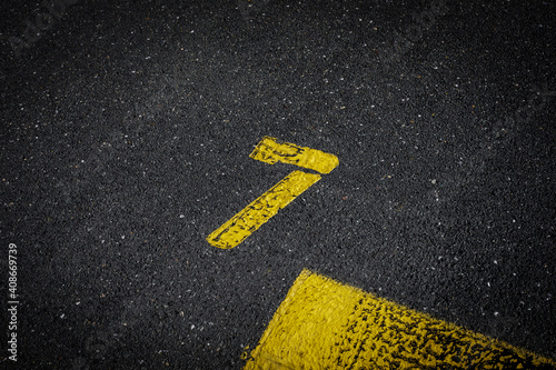 Grey asphalt road, yellow painted number seven on grey street, yellow lines like a corner on the road, space for text   © YK