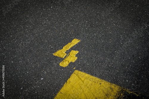 Grey asphalt road, yellow painted number four on grey street, yellow lines like a corner on the road, space for text   © YK