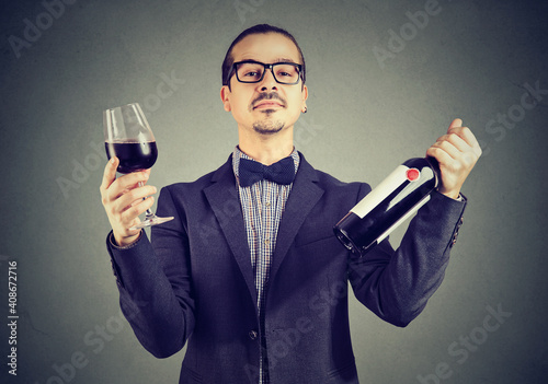 Photos Portrait of a wine expert holding glass of red wine and a bottle