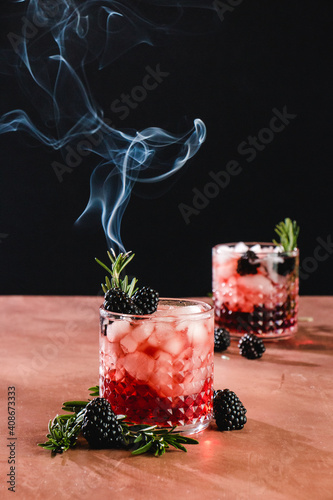 blackberry whiskey cocktail with burning rosemary garnish