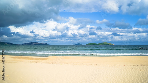 beach with white sand on Hainan Island, sunny weather, summer travel vacation, fluffy white clouds in the sky, travel in China, a beautiful beach with white fluffy clouds in the sky over the sky
