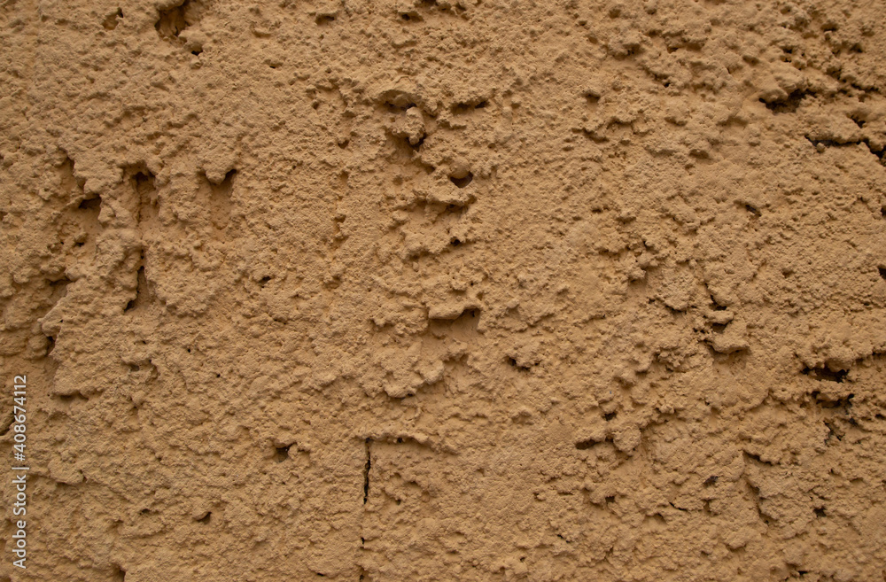 Old retro scrutched yellow brown plaster stucco wall background