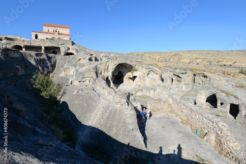 Cave town of Uplistsikhe in Georgia with Uplistsulis Eklesia above. Ruins of city in the rock. Tourists visiting Caucasus. photo