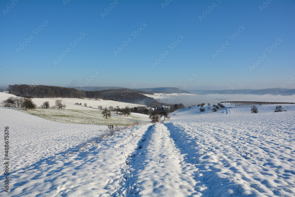Winter landscape with fields and fog in the valley, with a lot of snow