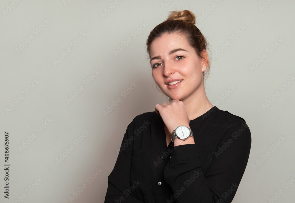 Beautiful young woman with long and healthy wavy hair posing in dress showing healthy figure and wearing wrist watch Beautiful young woman with long and healthy wavy hair posing in dress showing healthy figure and wearing wrist watch