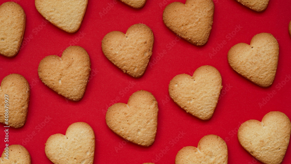 Valentine's Day and Mother's Day banner concept.Pattern of traditional homemade cookies, lots of heart shaped shortbread cookies on red background, top view, flat lay.Festive postcard Valentine's Day and Mother's Day banner concept.Pattern of traditional homemade cookies, lots of heart shaped shortbread cookies on red background, top view, flat lay.Festive postcard