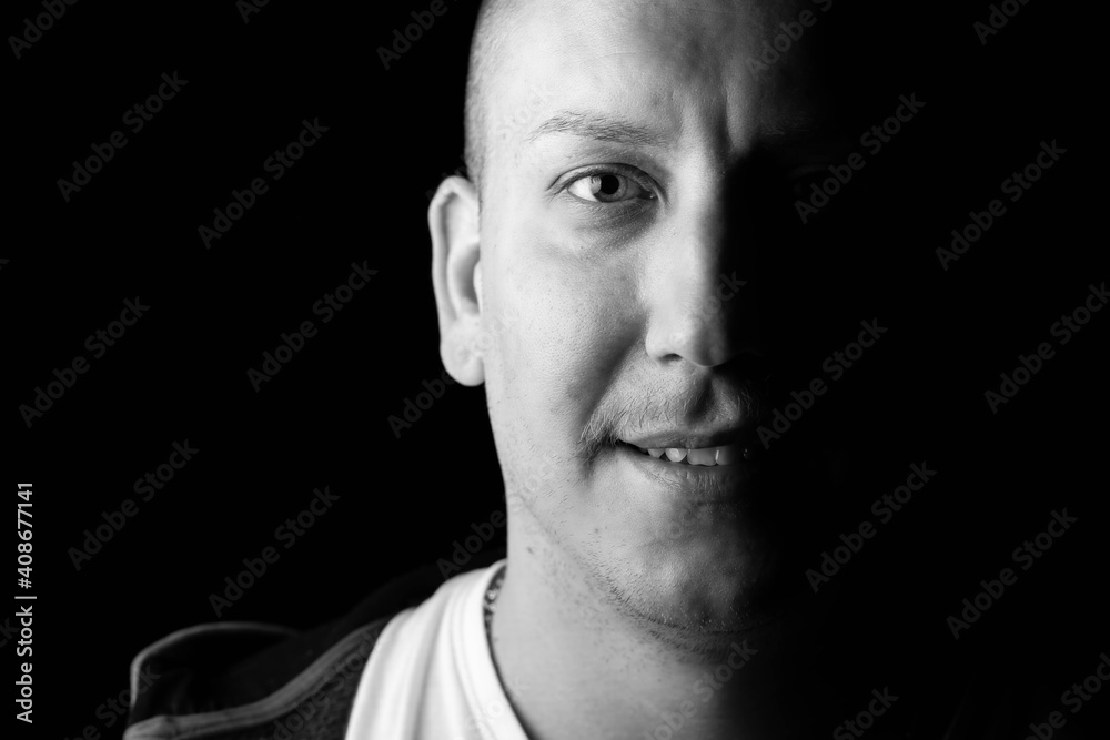 Close-up black and white portrait of a strong, confident male person smiling. Close-up black and white portrait of a strong, confident male person smiling.