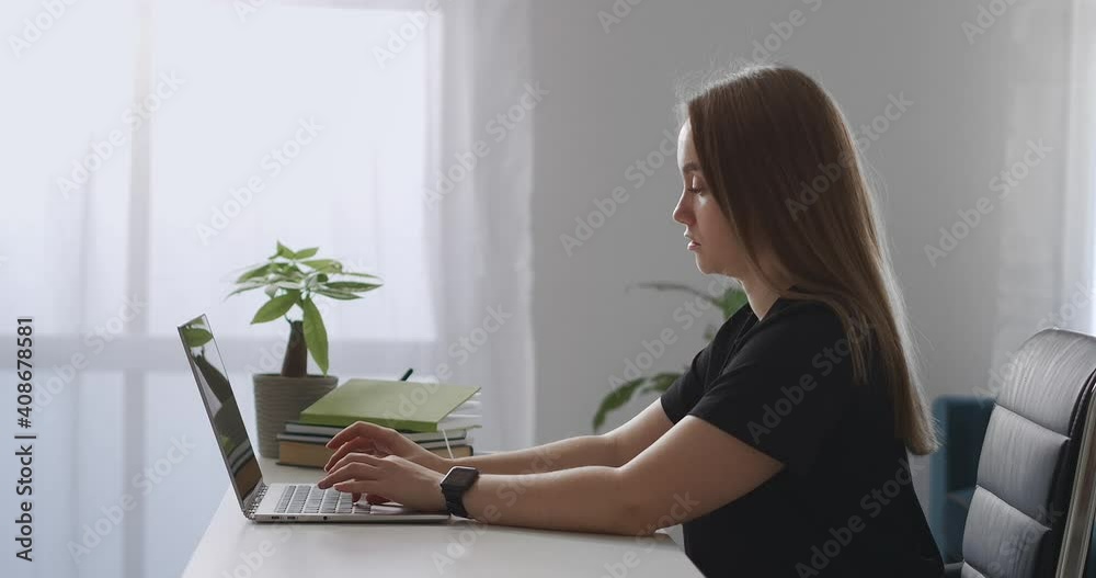 woman is typing messages in social networks, using internet by laptop in home, side view on young lady with notebook woman is typing messages in social networks, using internet by laptop in home, side view on young lady with notebook