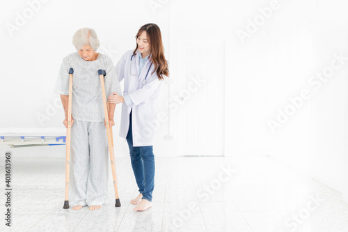 asian old learning to use crutches with female doctor, walk training and rehabilitation, elderly health promotion © jokekung