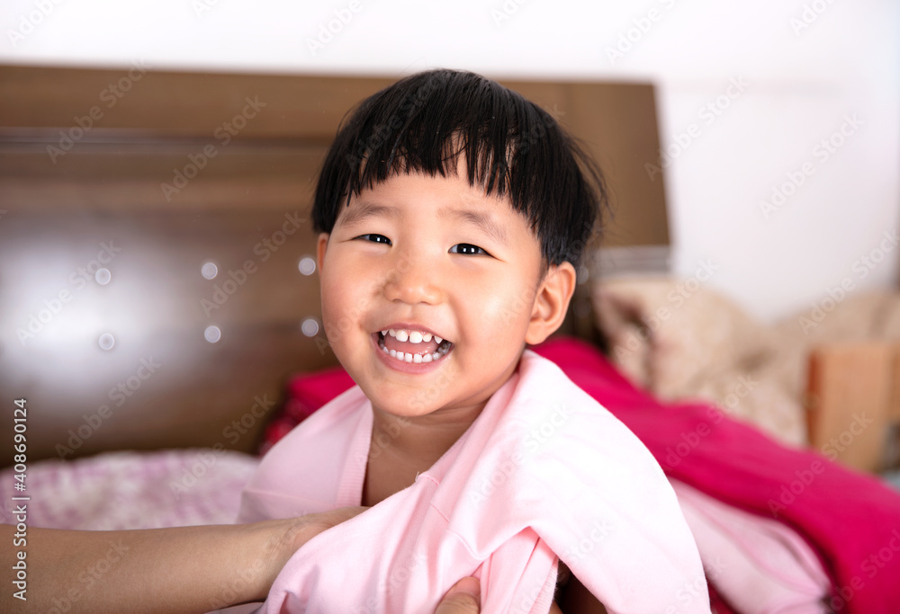 The little girl is wearing a coat on the bed The little girl is wearing a coat on the bed
