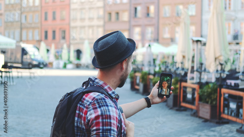 Medium shot of tourist making video call on smartphone with female tourist from other place. They exchanging impressions from travelings. photo