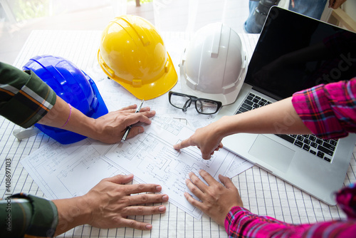 Workers and manager in safety helmets working with documents at factory .Engineer Concept